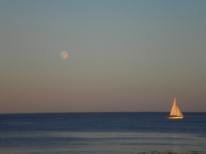Sailboat at sea with the Moon rising